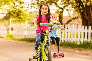 leende barn Framställ med Cyklar i de parkera foto