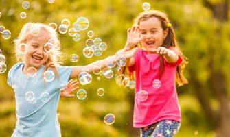 två litet barn flickor fångst tvål bubblor i lavendel- fält foto