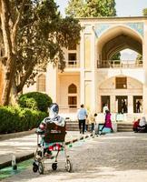 Kashan, Iran, 2022 - muslim kvinna i rullstol besök resa destination. familj i traditionell persisk fena trädgård Kashan, iran foto