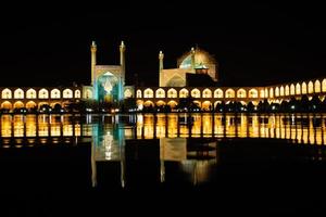 esfahan, iran - 15:e Maj, 2022 - ingång in i de fredag moské på natt, jame moské av isfahan med trädgård förgrund foto