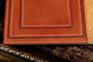 del av en brun läder plånbok eller fall med söm. foto