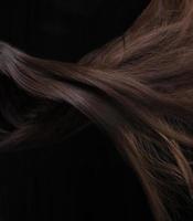 del av brun kvinna hår på en vit bakgrund. foto