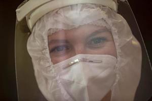 de ansikte av en kvinna läkare närbild i en skyddande kostym. foto