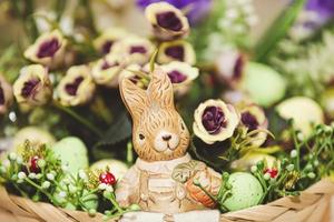 årgång påsk bakgrund med kanin statyett och lila blommor. foto