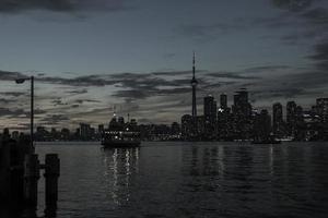 de toronto strandlinje på sent solnedgång med en passagerare färja korsning mellan Centrum ö och toronto. foto