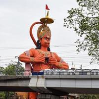 ny delhi, Indien - juni 21, 2022 - stor staty av herre hanuman nära de delhi metro bro belägen nära karol bagh, delhi, Indien, herre hanuman stor staty rörande himmel foto