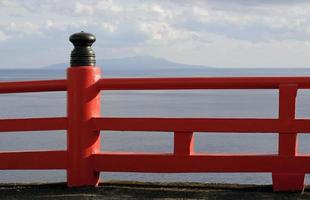 röd staket nära de kust med de hav i de bakgrund i enoshima, japan foto