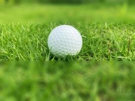 golf boll stänga upp på grön gräs på suddig skön landskap av golf kurs med soluppgång solnedgång tid på bakgrund.koncept internationell sport den där bero på precision Kompetens för hälsa avslappning. foto