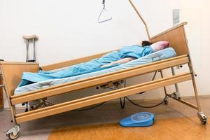 sluttande elektrisk sjukhus säng med patient på Hem foto