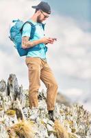 ung man handtag smartphone under i alpina trekk foto