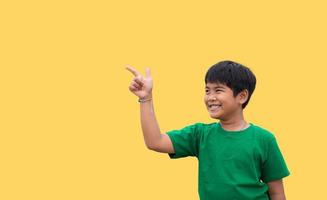 de pojke log och spetsig hans hand till hans sida. på en gul bakgrund foto