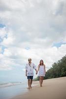 unga lyckliga par promenader på stranden leende foto