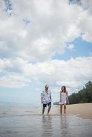 unga lyckliga par promenader på stranden leende foto