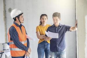 unga asiatiska ingenjörer som bygger ett hus foto