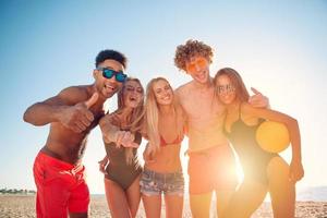 grupp av vänner spelar på strand volley på de strand foto