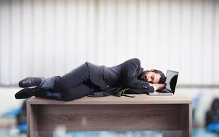 affärsman sovande över en skrivbord på grund av till överansträngning foto