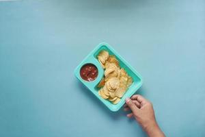 en skål chips och salsa på bordet, foto