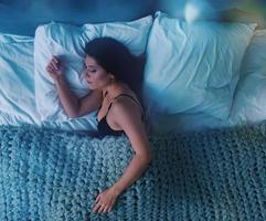 flicka sover i en mysigt säng under de natt. begrepp av koppla av och resten foto