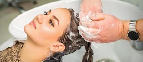 ung kvinna får hår tvätta foto