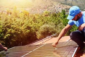arbetare montera energi systemet med sol- panel för elektricitet foto