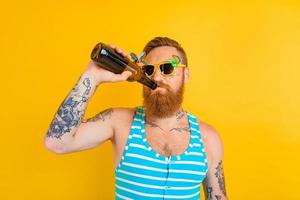 man med skägg och solglasögon drycker öl foto