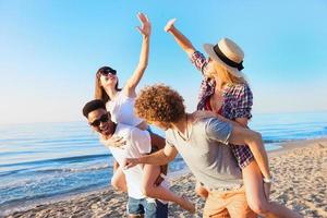 glad ung vänner njuter sommartid på de strand foto