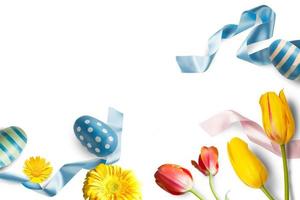 påsk dekorationer med ägg, blommor och blå band foto