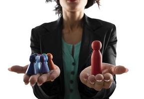 företag kvinna innehar trä- leksak formad som person. begrepp av företag lagarbete och ledarskap. isolerat på vit bakgrund foto