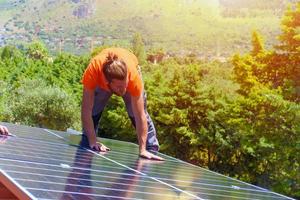 arbetare montera energi systemet med sol- panel för elektricitet foto