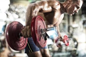 atletisk man Träning biceps på de Gym foto