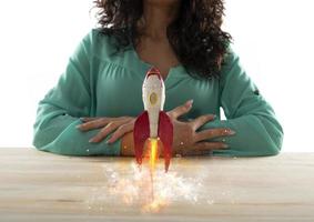 affärskvinna lanserar sitt företag med en raket. begreppet start och innovation. foto