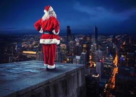 santa claus utseende ner på de stad väntar till leverera de presenterar foto