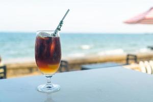 iced americano kaffe persika med havet bakgrund foto