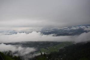 se av de landa ovan de moln by ovan de moln lolai kullar by och traditionell by täckt förbi moln i de morgon- innan soluppgång foto