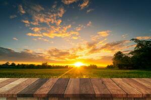 ris fält solnedgång och tömma trä tabell för produkt visa och montage. foto