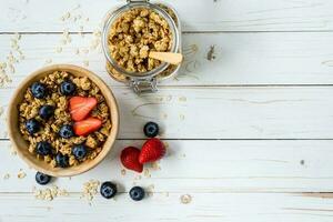 hemlagad granola och färsk bär på trä tabell med Plats. foto