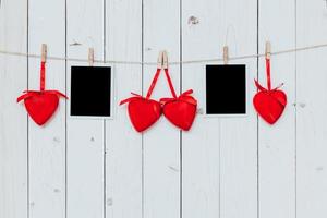 två Foto ram tom och röd hjärta hängande på vit trä bakgrund med Plats