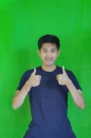 uttrycksfull tillfällig balinesisk asiatisk kille modell för reklam med grön skärm studio bakgrund foto