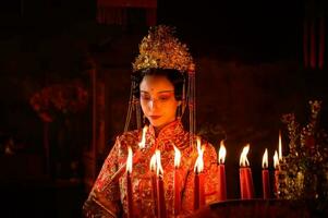 kinesisk kvinna göra lyckönskningar, be, och ljus ljus. på de tillfälle av de årlig kinesisk ny år festival, i en vördad helgedom eller tempel foto