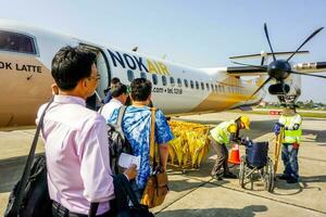 lampang, thailand 2018 de turist och affärsmän promenad upp de plan av nok luft på de lampang flygplats till bangkok. foto