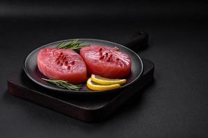 två färsk skivor av rå tonfisk filea med kryddor och örter foto