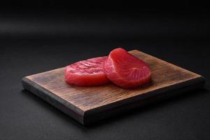 två färsk skivor av rå tonfisk filea med kryddor och örter foto