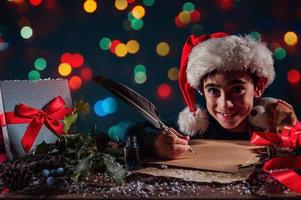 barn med jul hatt skrivningar en brev till santa claus för gåvor foto