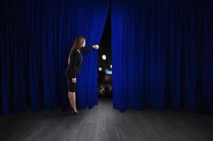 kvinna öppen blå gardiner av de teater skede foto