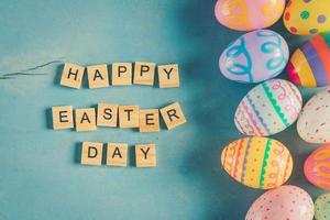 färgrik påsk ägg och trä text Lycklig påsk dag på blå pastell Färg trä bakgrund med Plats. foto
