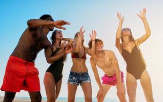 grupp av vänner spelar på strand volley på de strand foto