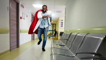 läkare handlingar tycka om en superhjälte i sjukhus till bekämpa pandemi av covid19 coronavirus. blå bakgrund foto