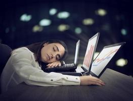 kvinna arbetstagare falls sovande medan samtidigt arbetssätt på tre bärbara datorer foto