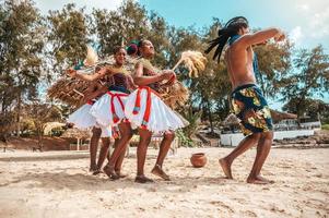 kenyan människor dansa på de strand med typisk lokal- kläder foto
