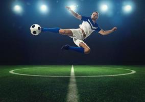 fotboll anfallare träffar de boll med ett akrobatisk sparka foto
